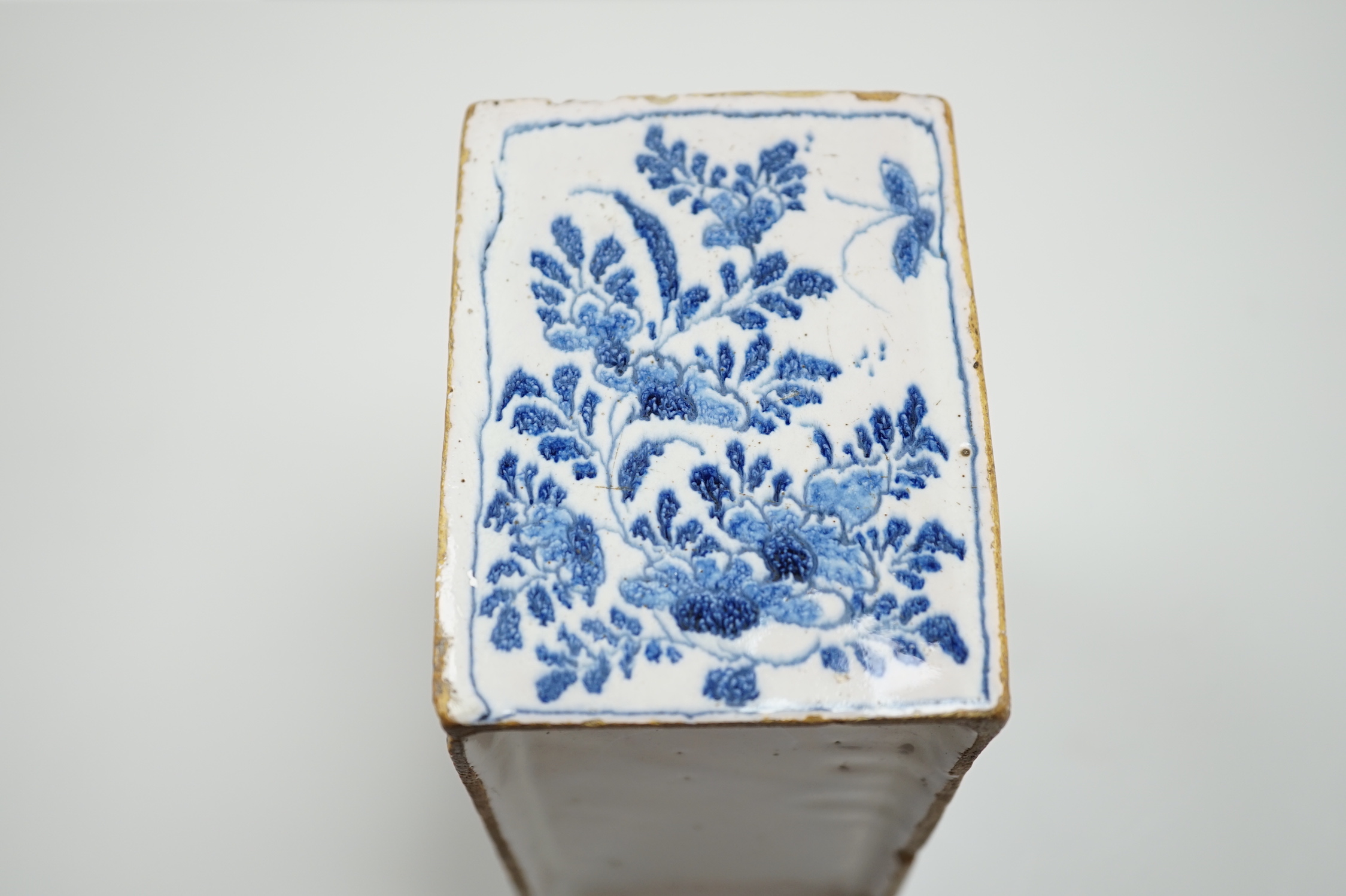 A mid 18th century English delftware flower brick, probably Lambeth, painted in underglaze blue with stylised chrysanthemums, 15cm wide